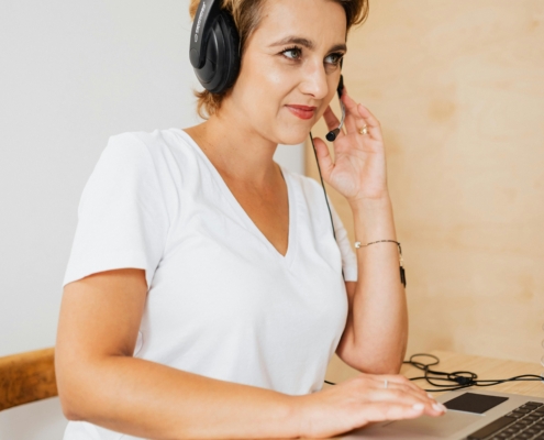 Frau_sitzend_am_PC_mit Headset