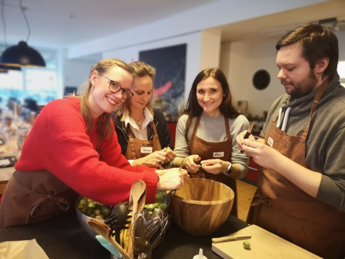 Mitarbeiter kochen zusammen und schälen Rosenkohl