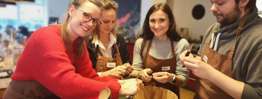 Mitarbeiter kochen zusammen und schälen Rosenkohl